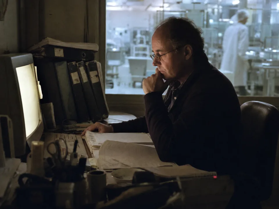 Quality manager at a desk beside the cleanroom window